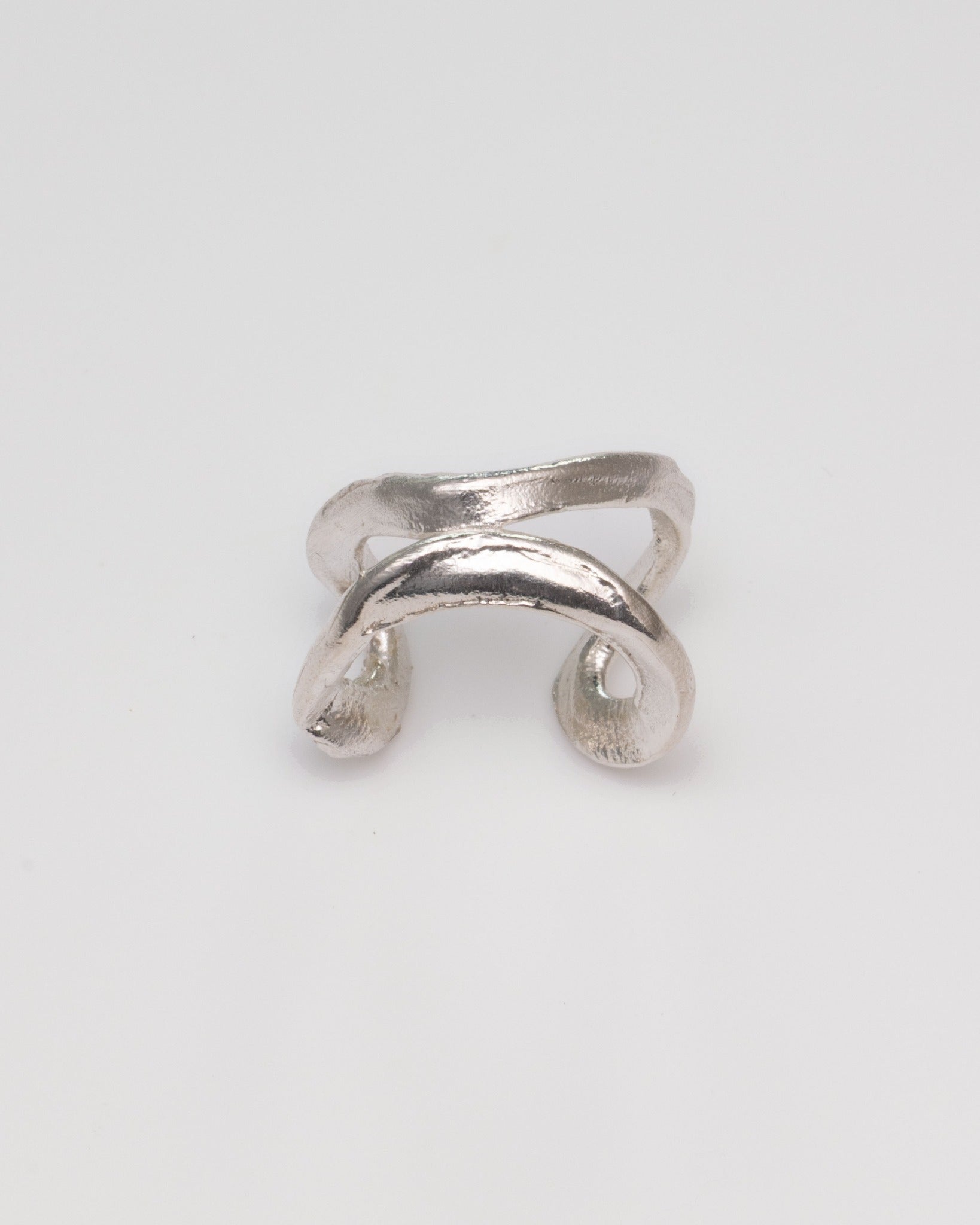 A textured silver ring with a unique, organic curved design and open ends, photographed on a clean white background.